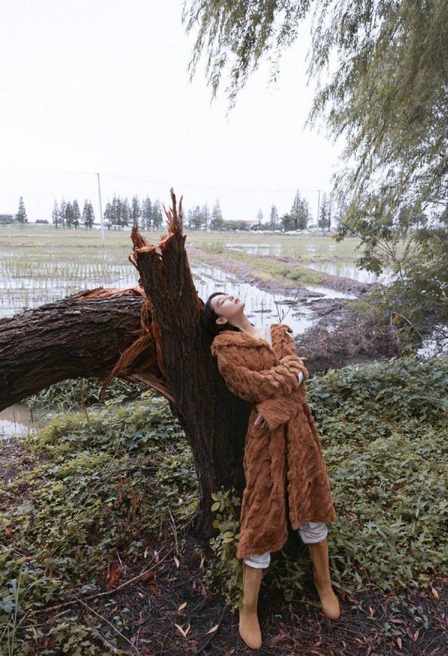 美女拿个狗尾巴草都好看，张馨予穿露脐装大秀长腿，氛围感太强